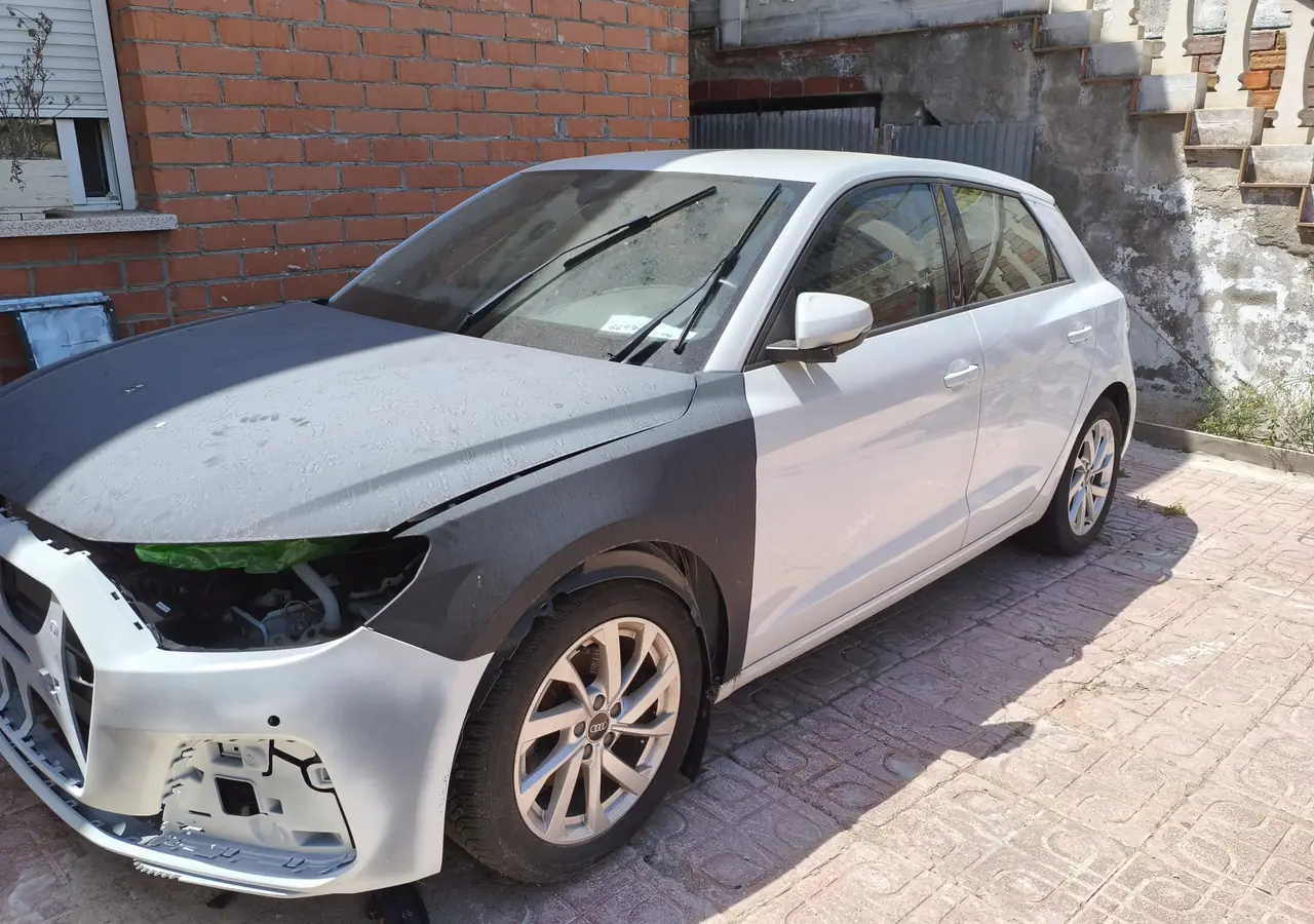 Audi A1 blanco fotografiado de lado en el desguace