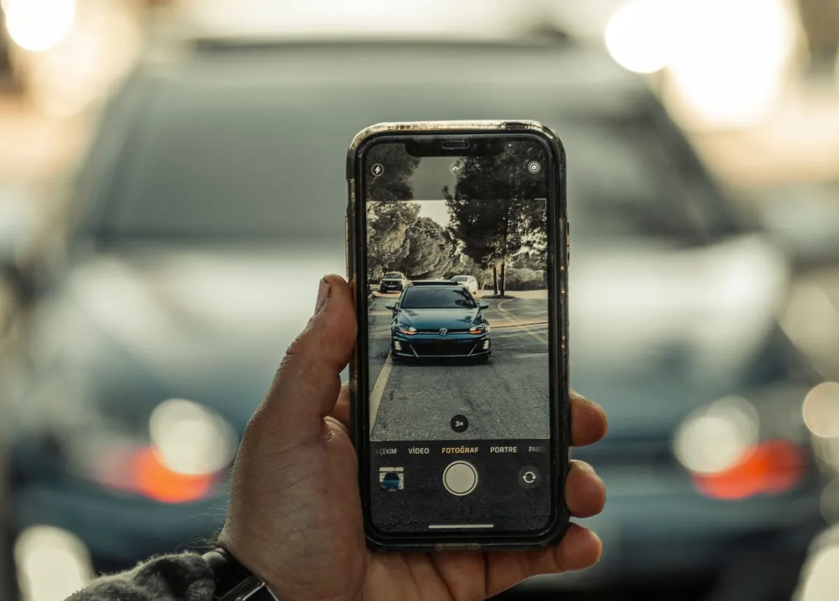 Una persona fotografía un coche con el móvil